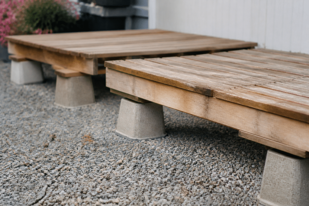 Palettes en bois sureleves sur plots beton et gravier