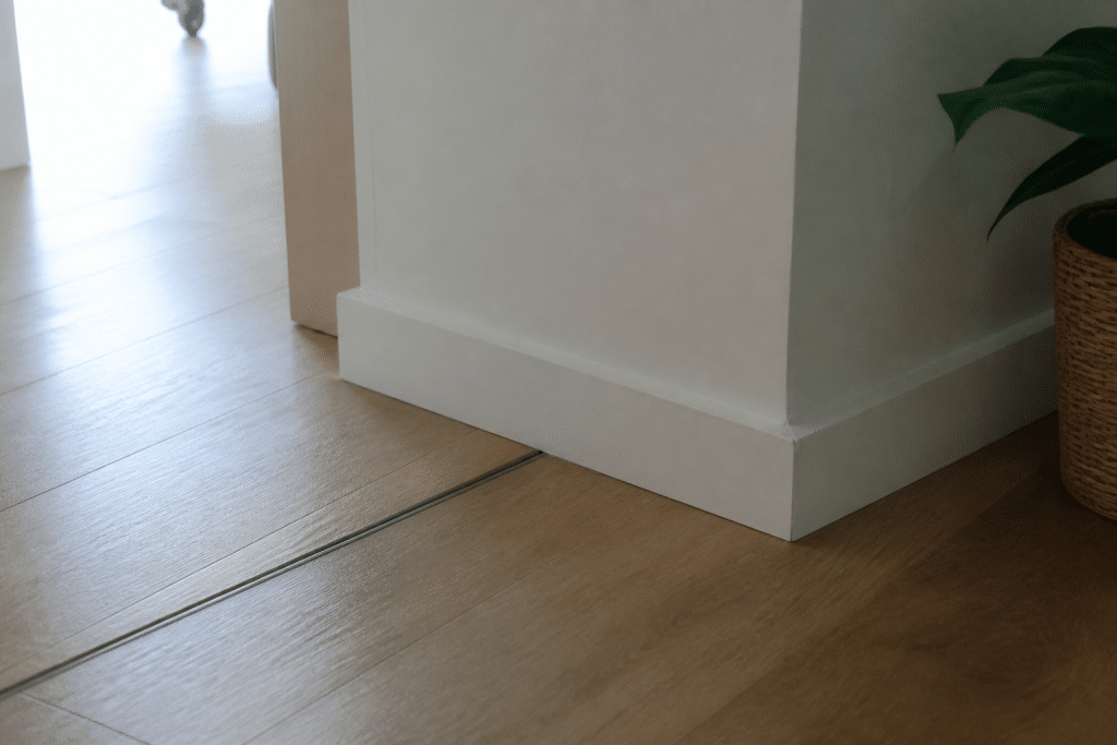Plinthe blanche couvrant joint dilatation sol stratifié