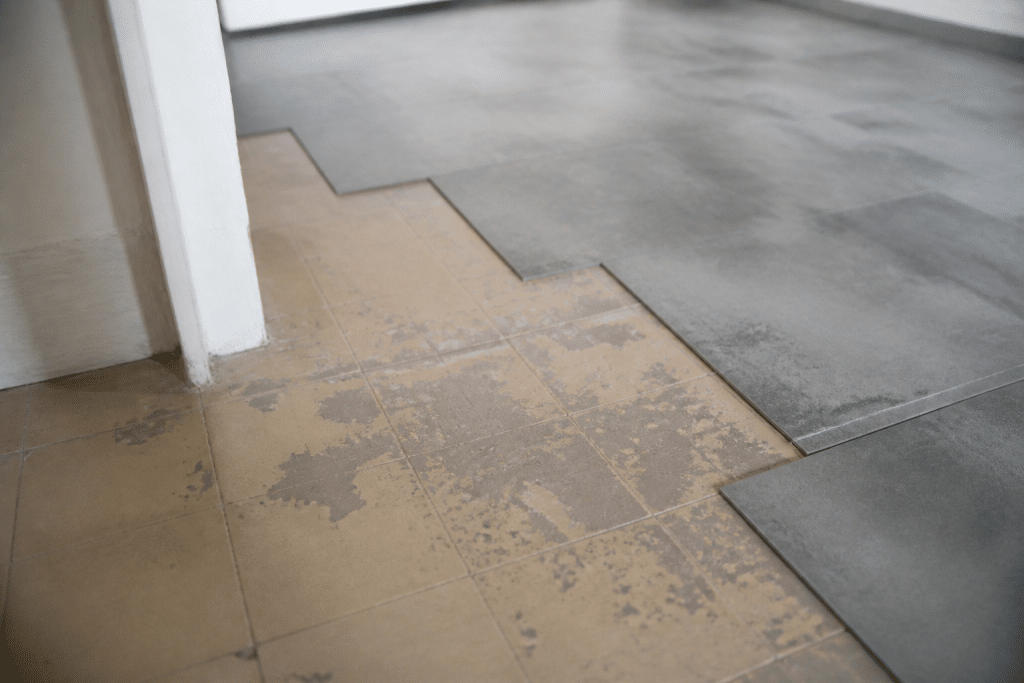 Carrelage ancien couvert de peinture beige et dalles clipsables grises